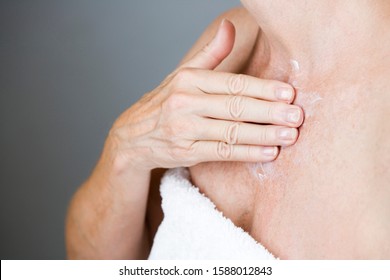 A Senior Woman Applying Moisturising Cream To Her Chest