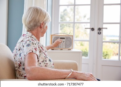 Senior Woman In An Armchair Listening To The Radio At Home