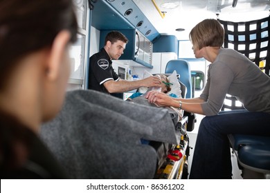 Senior woman being given oxygen in an ambulance, caregiver at side - Powered by Shutterstock