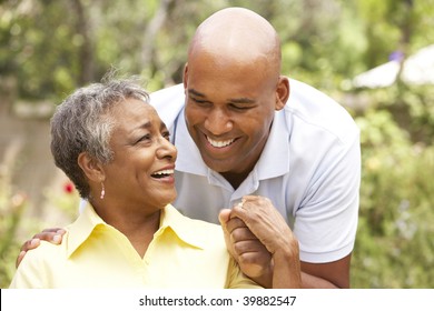 Senior Woman Being Hugged By Adult Son