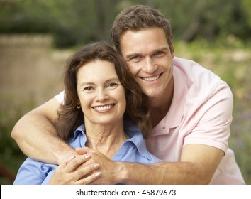 Senior Woman Being Hugged By Adult Son