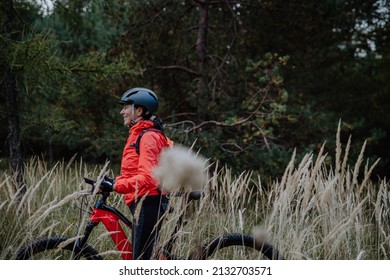 Senior Woman Biker Walking With Bike Outdoors In Nature In Autumn Day.