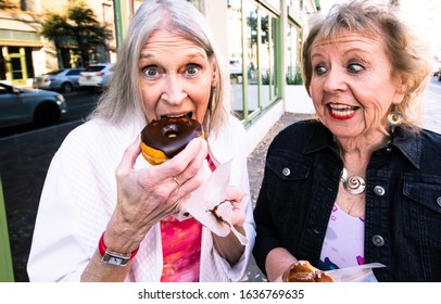 Senior Woman Biting Into A Donut