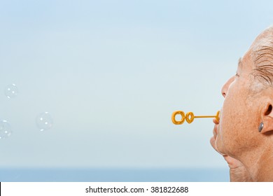 Senior Woman Blowing Bubbles