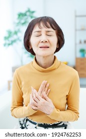 Senior Woman With Both Hands On Her Chest