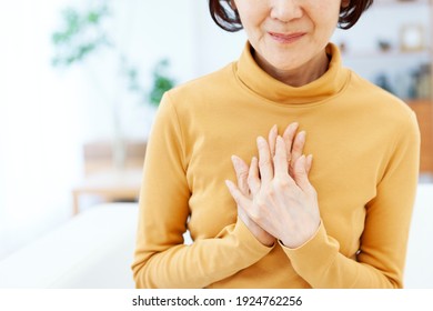 Senior Woman With Both Hands On Her Chest