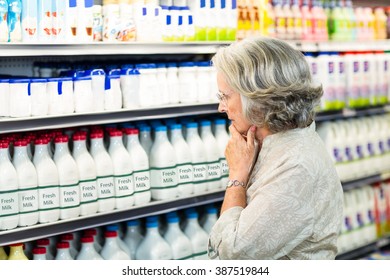 Senior Woman Buying Milk At The Supermarket