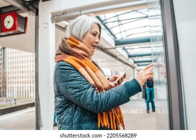 Senior woman buys the train tickets with the automatic machine - Powered by Shutterstock