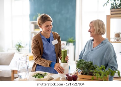 Senior Woman With Caregiver Or Healthcare Worker Indoors, Preparing Healthy Smoothie.