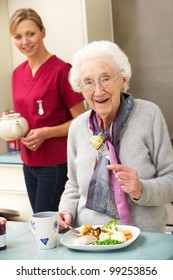 Senior Woman With Carer Eating Meal At Home