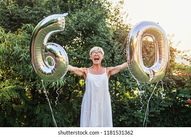 Senior Woman Celebrating Her 60th Birthday, With Balloons 