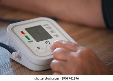 Senior Frau überprüft den Blutdruck und die Herzfrequenz mit digitalem Druckmesser von sich zu Hause. Ältere Frau kümmert sich um die Gesundheit. Gesundheits- und Medizinkonzept.