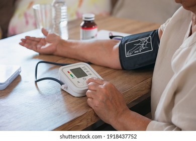 Senior woman is checking blood pressure and heart rate with digital pressure gauge by herself at home.Older woman taking care for health. Health and Medical concept.