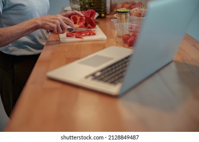 Senior Woman Chopping Vegetables At Home Kitchen