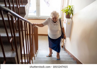 Senior woman climbing staircase with difficulty 
