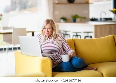 Senior Woman With Coffee And Laptop Indoors At Home, Relaxing.