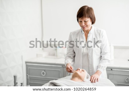 Similar – Female doctor giving medication to elderly patient