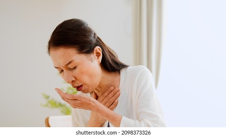 Senior Woman Coughing At Home	