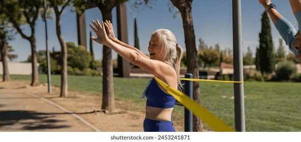 Senior woman crosses finish line winning outdoor marathon championship while celebrating by raising her arms - Powered by Shutterstock