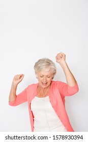 A Senior Woman Dancing To Music On An Mp3 Player