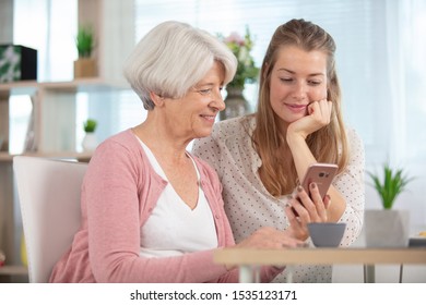 Senior Woman And Daughter With Mobile Phone