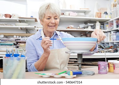 Senior Woman Decorating Bowl In Pottery Class