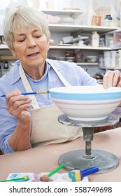 Senior Woman Decorating Bowl In Pottery Class