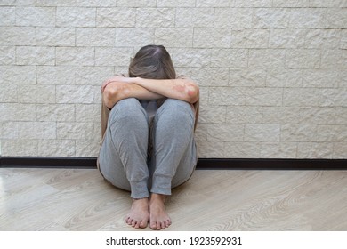 Senior Woman With Depression Stress Sad Sitting On The Floor. The Concept Of Sadness, Loneliness, Old Age. The Concept Of Psychological Health, Emotional Anxiety, Panic Attack, Menopause, Migraine.