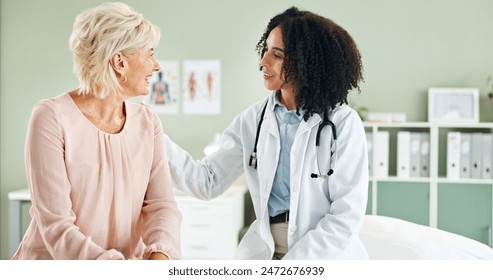 Senior woman, doctor and comfort in consultation with discussion, smile and good news at wellness clinic. Medic, people and happy with support, counselling and review for health on bed at hospital - Powered by Shutterstock