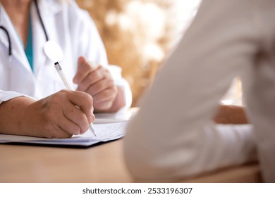 Senior woman doctor consults with young patient in modern medical office, doctor explaining and diagnosis with patient about health and treatment while writing on notes, medical and insurance. - Powered by Shutterstock