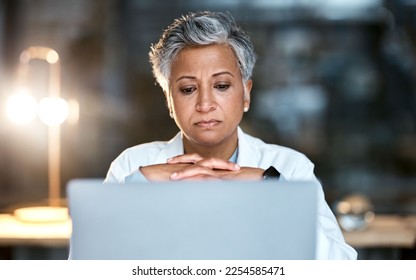 Senior woman, doctor and laptop at night thinking for healthcare solution, idea or strategy at hospital. Elderly female medical expert working late on computer and contemplating decision or choice - Powered by Shutterstock