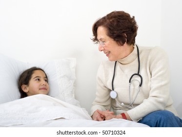 Senior Woman Doctor Visiting Child Penitent At Home