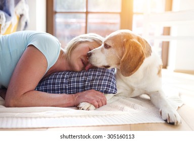 Senior Woman With Dog Inside Of Her House. 