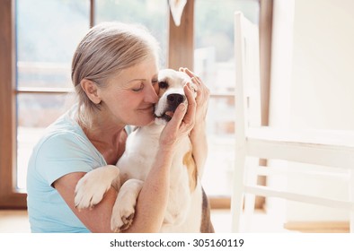 Senior Woman With Dog Inside Of Her House. 