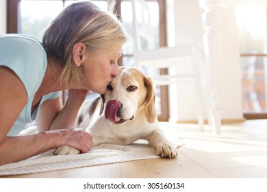 Senior Woman With Dog Inside Of Her House. 