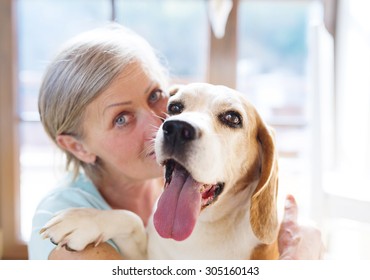 Senior Woman With Dog Inside Of Her House. 