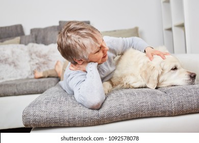 Senior Woman With Dog Retriever On The Couch For Relaxation