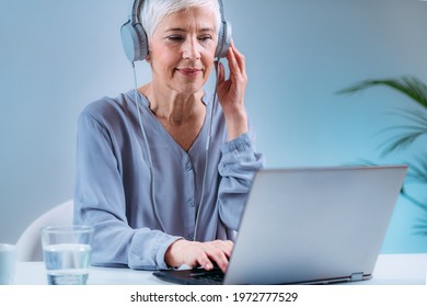 Senior Woman Doing Audiogram Hearing Test At Home, Using Laptop