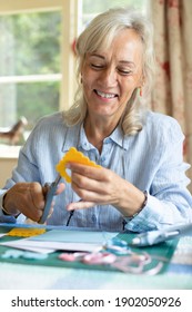 Senior Woman Doing Craft Scrapbooking Or Making Greetings Card  At Home