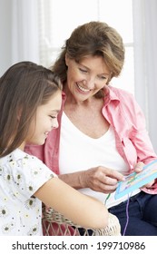 Senior Woman Doing Cross Stitch With Granddaughter