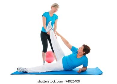 Senior Woman Doing Fitness Exercise With Help Of Trainer At Sport Gym