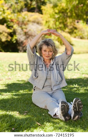 Senior woman doing her streches in the park