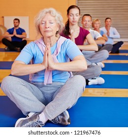 Senior Woman Doing Relaxation Exercise In Yoga Class In A Gym