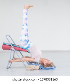 Senior Woman Doing Yoga With Chair At Home. Stretching Exercises