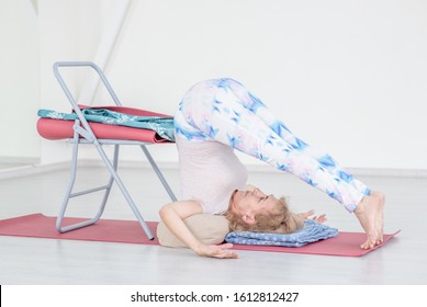 Senior Woman Doing Yoga With Chair At Home. Stretching Exercises