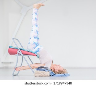 Senior Woman Doing Yoga With Chair. Stretching Exercises