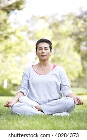 Senior Woman Doing Yoga In Park