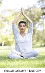 Senior Woman Doing Yoga In Park