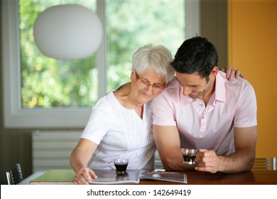 Senior woman drinking coffee with her son