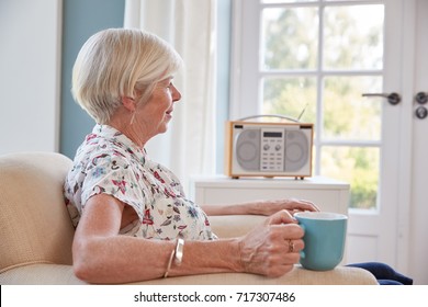 Senior Woman Drinking Tea And Listening To Radio At Home